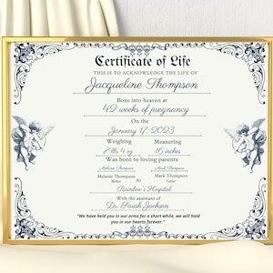 May include: A Certificate of Life document in a gold frame featuring dark blue decorative borders and cherub illustrations. The text includes the name Jacqueline Thompson, birth details of 8 lbs 4 oz and 16 inches, and a memorial quote at the bottom.