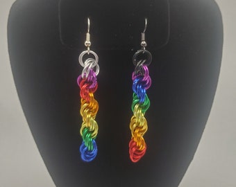 May include: A pair of rainbow colored earrings made of metal wire. The earrings are twisted and have a silver hook.