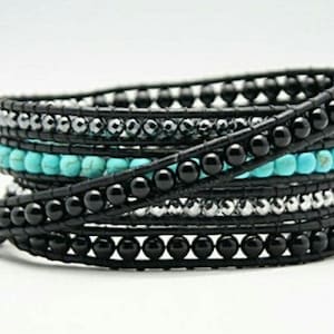 May include: A multi-strand wrap bracelet with black onyx beads, turquoise beads, and silver beads. The bracelet is made of leather and is wrapped around the wrist.