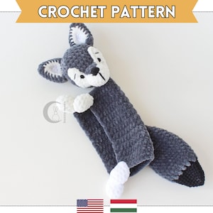Può includere: Un giocattolo di amigurumi a forma di lupo in crochet grigio con dettagli bianchi. Il lupo ha una coda lunga e una texture soffice.