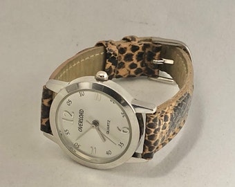Montre femme Overload, bracelet imitation peau de serpent, pile neuve !