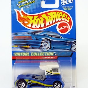 May include: A blue and white Hot Wheels toy car with a white cab and a blue chassis. The car has a yellow stripe and the number 17 on the side. The car is packaged in a blue and red blister pack with the Hot Wheels logo and the words "Virtual Collection" and "Semi-Fast".