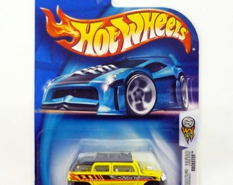 May include: A yellow Hot Wheels 2004 First Editions "Rockster" die-cast toy car with a black roof and black and red stripes on the side. The car is on a blue and white card with the Hot Wheels logo.