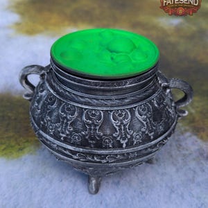 May include: A silver cauldron with intricate details and three legs. The cauldron has a green lid with a bubbling effect.