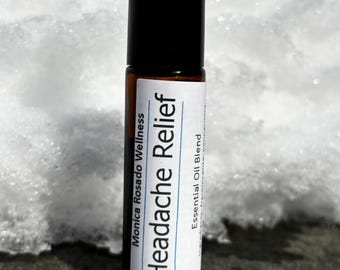 May include: A small brown glass bottle with a black roll-on top. The label is white with black text that reads "Headache Relief" and "Monica Rosado Wellness" and "Essential Oil Blend".