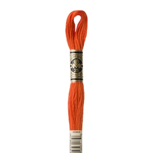 May include: A spool of DMC embroidery floss in colour 946, a bright orange. The spool is labelled with the DMC logo and the number 25, indicating the length of the floss. The label also includes the text "ULINE SPEC" and a barcode.