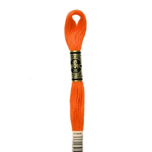 May include: A spool of DMC embroidery floss in colour 947, a bright orange. The spool has a gold label with the DMC logo and the text "DMC Special 25 18.7 yd". The barcode and the number 947 are printed on the label.
