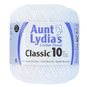 Puede incluir: Bola de hilo de crochet blanco con la etiqueta "Aunt Lydia's Classic 10 Crochet Thread" y una cara de mujer en la etiqueta. La etiqueta también dice "100% Mercerized Cotton/Coton Mercerisé/Algodón Mercerizado".