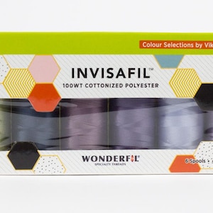 May include: A box of INVISAFIL thread spools. The box is white with a green top and colorful geometric shapes. The text "INVISAFIL" and "100WT COTTONIZED POLYESTER" are printed on the box. The box contains six spools of thread.