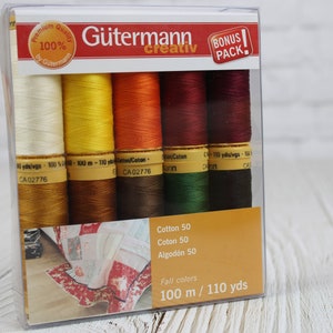 Pode incluir: Um pacote de plástico transparente de bobinas de linha Gütermann creativ em cores de outono. As bobinas são em tons de creme, amarelo, laranja, bordô, verde e marrom. Cada bobina contém 100 m de linha de algodão. O pacote inclui um bônus.