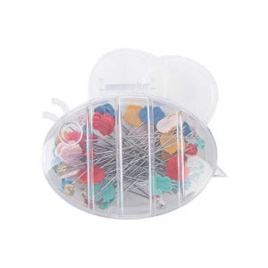 Op de afbeelding: Een doorzichtige plastic container in de vorm van een bij, gevuld met gekleurde naalden. De naalden hebben verschillende gekleurde koppen, waaronder rood, blauw, groen en geel.