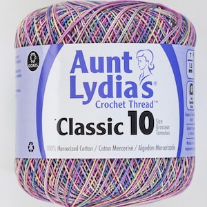 Puede incluir: Ovillo de hilo de ganchillo Aunt Lydia's Classic 10 multicolor. La etiqueta dice "100% Algodón Mercerizado". El hilo es del tamaño 7, 1,5 mm.