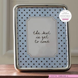 Könnte beinhalten: Ein rechteckiger silberner Bilderrahmen mit abgerundeten Ecken. Der Rahmen enthält einen Druck mit hellblauem Hintergrund und schwarzen Punkten. Der Druck trägt die Worte "the best is yet to come" in schwarzer Schrift. Ein weißer Kreis mit dem Wort "PRINTABLE" befindet sich oben rechts.