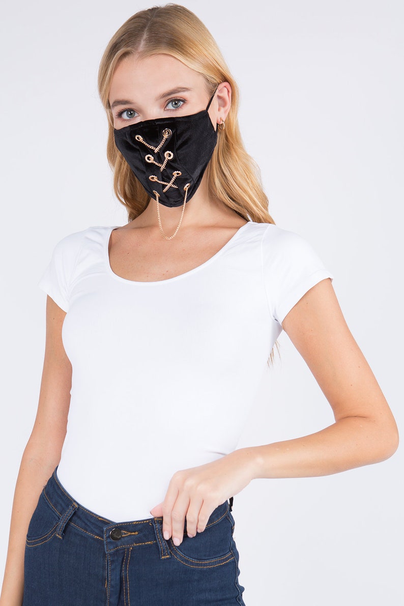 May include: Black velvet face mask with gold chain detail and criss-cross lacing.