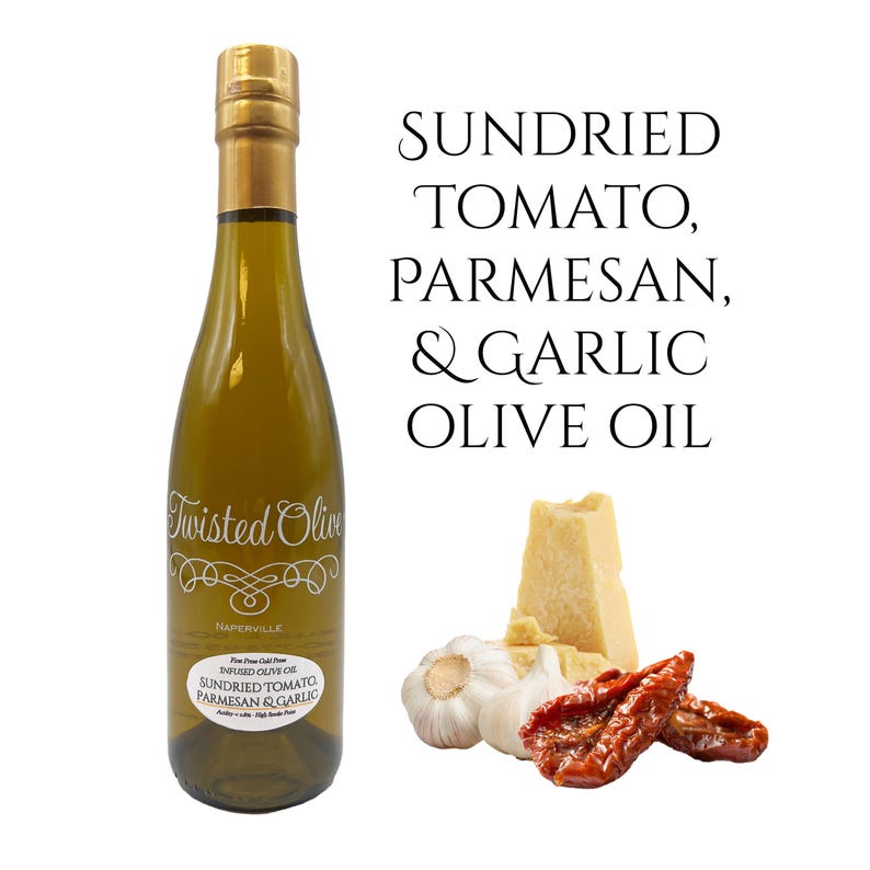 May include: A glass bottle of Twisted Olive Sundried Tomato, Parmesan & Garlic infused olive oil. The bottle is labeled with the company name and product description. The image also shows ingredients used in the oil, including sun-dried tomatoes, parmesan cheese, and garlic cloves.