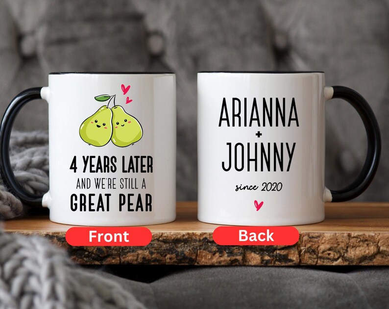 Puede incluir: Taza de cer&aacute;mica blanca con asa y borde negros. La parte delantera de la taza presenta una imagen de dibujos animados de dos peras con el texto "4 Years Later and We're Still a Great Pear". La parte posterior de la taza tiene el texto "Arianna + Johnny since 2020".