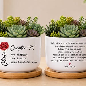May include: Two white ceramic planters on bamboo saucers, each filled with assorted green succulents. The left planter features a red rose graphic, the name Olivia, and the text Chapter 75. The right planter displays a poem and EST. 1956.