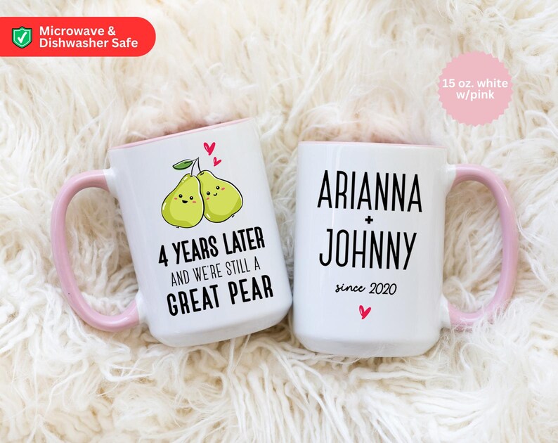 Puede incluir: Dos tazas de cer&aacute;mica blanca con asas rosas. Una taza tiene un dise&ntilde;o de pera y el texto "4 a&ntilde;os despu&eacute;s y seguimos siendo una gran pera". La otra taza tiene el texto "Ariana + Johnny desde 2020".