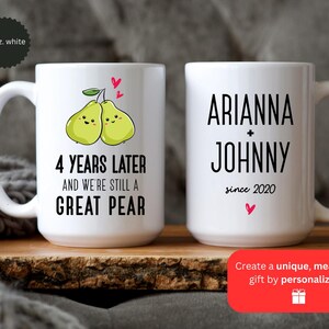 Puede incluir: Taza de cer&aacute;mica blanca con un dise&ntilde;o de pera y el texto "4 a&ntilde;os despu&eacute;s y seguimos siendo una gran pera". Una segunda taza de cer&aacute;mica blanca con el texto "Arianna + Johnny desde 2020".