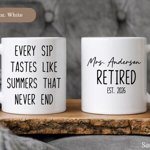 May include: Two white ceramic mugs with black text. One mug reads "EVERY SIP TASTES LIKE SUMMERS THAT NEVER END." The other mug says "Mrs. Anderson RETIRED EST. 2026." Both mugs are 11 oz.