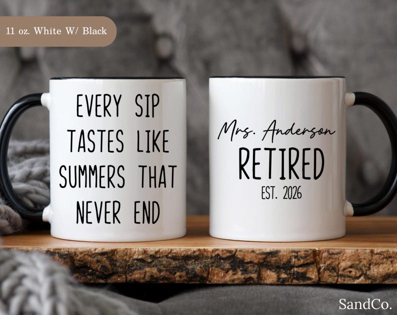 May include: Two white ceramic mugs with black handles and rims. One mug reads "EVERY SIP TASTES LIKE SUMMERS THAT NEVER END." The other mug says "Mrs. Anderson RETIRED EST. 2026."