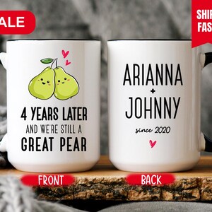 Puede incluir: Taza de cer&aacute;mica blanca con asa negra. La parte delantera de la taza tiene una imagen de dibujos animados de dos peras con caras y el texto "4 Years Later and We're Still a Great Pear". La parte posterior de la taza tiene el texto "ARIANNA + JOHNNY since 2020".