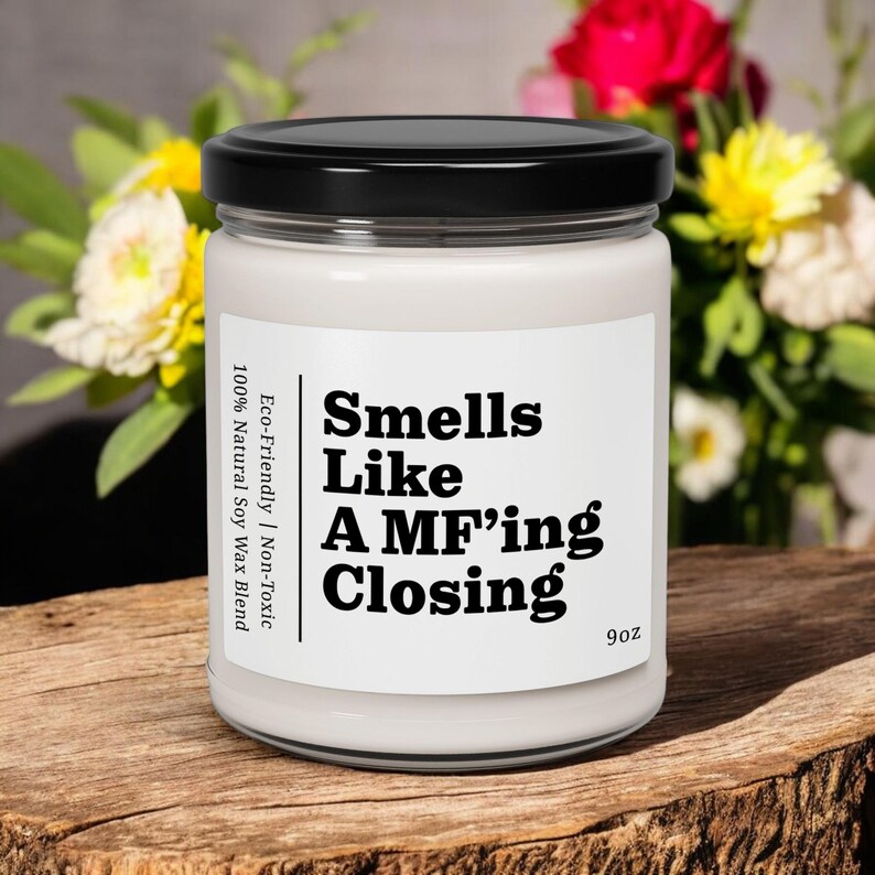 May include: A white candle with a black label that reads "Smells Like A MF'ing Closing" and "Eco-Friendly | Non-Toxic 100% Natural Soy Wax Blend" with a 9oz size.