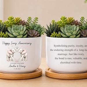 May include: Two white ceramic planters on bamboo saucers, each filled with green succulents. One planter features two elephants, the text Happy Ivory Anniversary, 14 YEARS TOGETHER, Amelia & Henry, 11.28.2012. The other displays text about marriage.