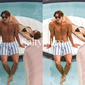 May include: Two people are sitting by a pool. The person in the foreground is wearing white and blue striped swim trunks and sunglasses. The person in the background is wearing a black bikini and sunglasses. The pool is blue and there is a white wooden platform around the pool.