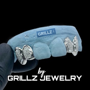 Most chosen custom fangs, solid frames, FREE diamond dust, middle two teeth skipped, high quality, fast, express delivered by Grillz jewelry