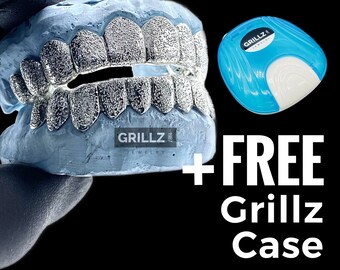 Może przedstawiać: Srebrne grillz z fakturą przypominającą diament, prezentowane na niebieskim modelu. Grillz są pakowane w niebieskie etui z napisem "Grillz Jewelry" na etui. Tekst "FREE Grillz Case" jest wyświetlany białymi literami na czarnym tle.