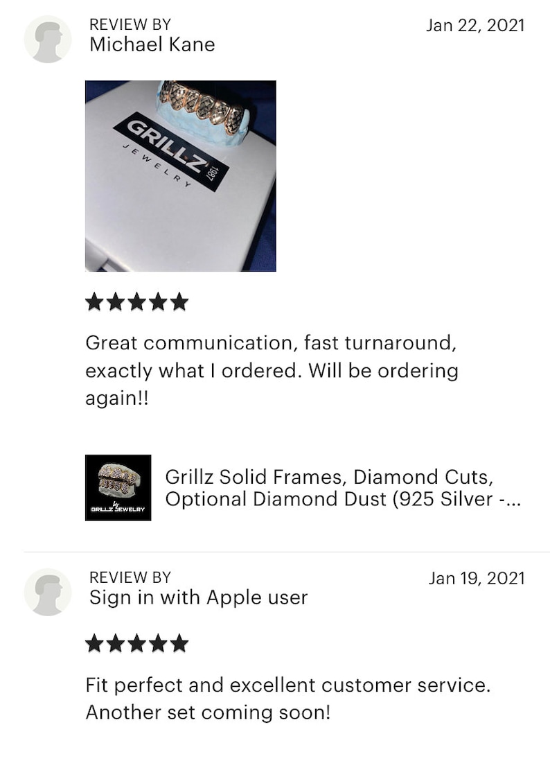 K&ouml;nnte beinhalten: Nahaufnahme einer goldenen Grillz mit Diamantbesatz. Die Grillz werden auf einer wei&szlig;en Box mit dem Aufdruck "Grillz Jewelry" pr&auml;sentiert.