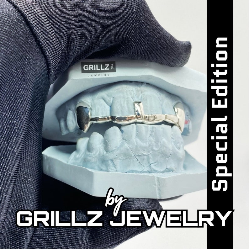 K&ouml;nnte beinhalten: Silberne Grillz mit einem einseitigen Zahndesign, auf einem blauen Zahnmodell ausgestellt. Die Grillz sind mit "Grillz Jewelry" und "Special Edition" gekennzeichnet.