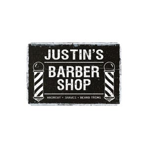 May include: A rectangular black and white barber shop sign with the text "JUSTIN'S BARBER SHOP". The sign includes barber poles on each side and the words "HAIRCUT • SHAVES • BEARD TRIMS" at the bottom.