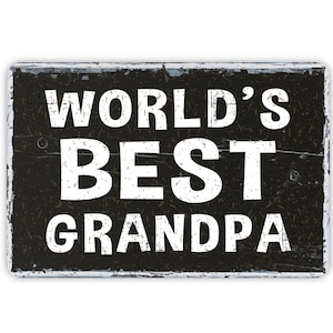 May include: Black and white sign with distressed wood grain texture. The sign reads "WORLD'S BEST GRANDPA".
