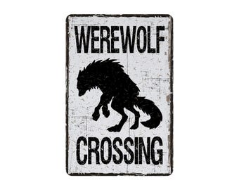 May include: A rectangular metal sign with a distressed white background and black text and graphic. The sign reads "WEREWOLF CROSSING" above and below a black silhouette of a werewolf.