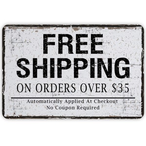 May include: A rectangular, distressed white sign with black text. The words "FREE SHIPPING" are prominently displayed at the top, followed by "ON ORDERS OVER $35". Additional text below reads "Automatically Applied At Checkout No Coupon Required".