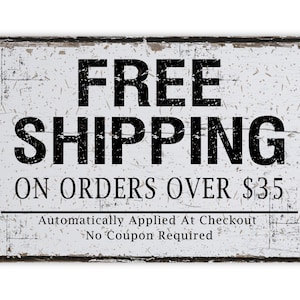 May include: A rectangular, distressed white sign with black text that reads "FREE SHIPPING" and "ON ORDERS OVER $35." The sign has a black border and additional text at the bottom. The sign has a vintage, rustic aesthetic.