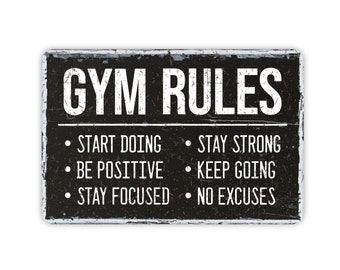 Könnte beinhalten: Schwarz-weißes Schild mit dem Text "GYM RULES" und einer Liste von Regeln: "Start Doing", "Stay Strong", "Be Positive", "Keep Going", "Stay Focused", "No Excuses".
