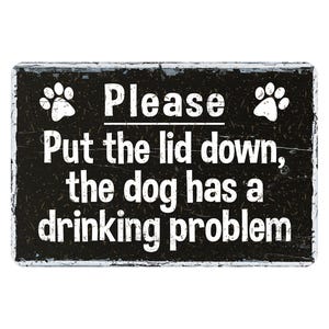 May include: Black and white sign with a distressed look. It says "Please put the lid down, the dog has a drinking problem." with paw prints on either side of the text.
