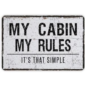 May include: White wooden sign with black text that reads "My Cabin My Rules. It's That Simple."