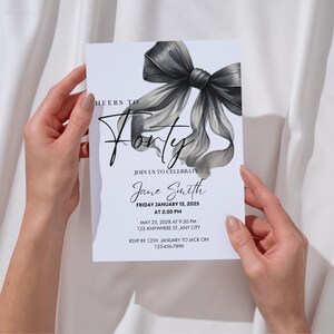 Può includere: Un invito di compleanno in bianco e nero con un grande fiocco elegante. L'invito recita "Cheers to Forty" e include il nome "Jane Smith", la data "Friday January 15, 2025", e l'ora "2:30 PM".