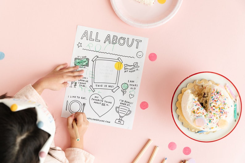 May include: A printable "All About Me" worksheet for kids with a blank space for a photo, a heart for favorite things, and a trophy for what they are good at. The worksheet is on a pink table with a birthday cake and colored pencils.