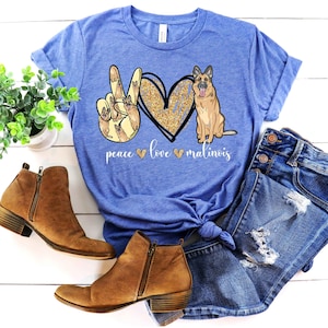 May include: A blue t-shirt with a peace sign made of Malinois dogs, a heart with glitter, and the text "peace love malinois".