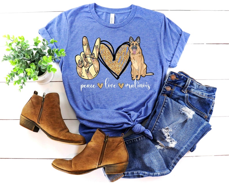 May include: A blue t-shirt with a peace sign made of Malinois dogs, a heart with glitter, and the text "peace love malinois".