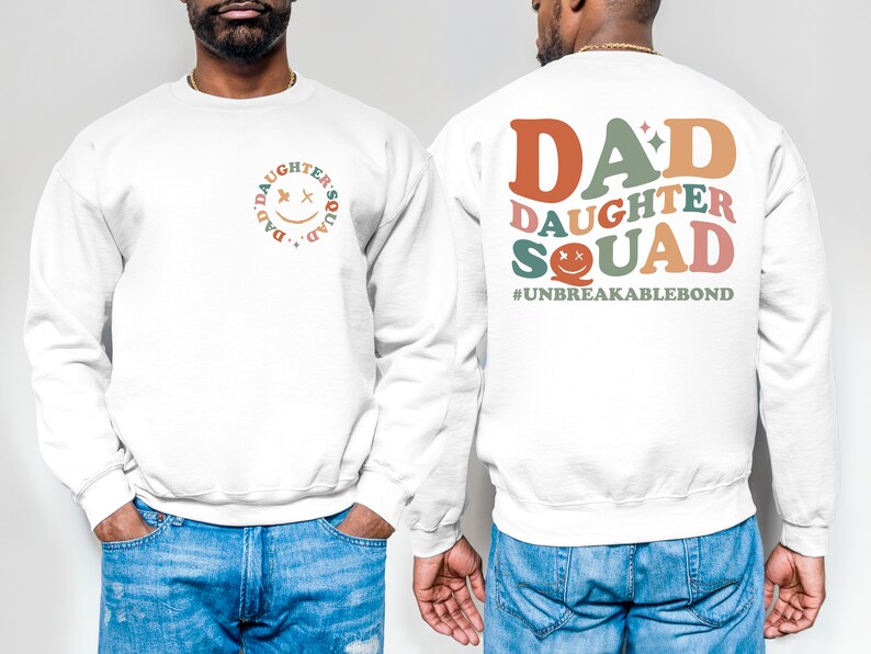 Puede incluir: Sudadera blanca con un gr&aacute;fico colorido en la espalda que dice "DAD DAUGHTER SQUAD #UNBREAKABLEBOND". La parte delantera de la sudadera tiene un gr&aacute;fico m&aacute;s peque&ntilde;o de una cara sonriente con las palabras "DAD'S DAUGHTER SQUAD" alrededor.