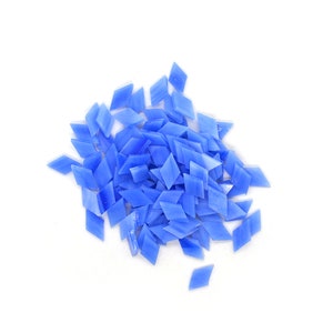 May include: A pile of small, light blue diamond-shaped glass tiles. The tiles are scattered on a white background.