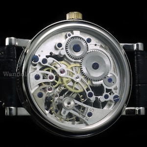 May include: A silver-toned wristwatch with a transparent face, showcasing the intricate internal mechanisms. The watch features numerous gears, jewels, and a gold-colored crown. The black leather band complements the watch's detailed design. The watch is a luxury item.