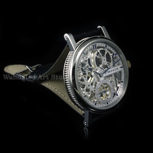 May include: A silver-toned skeleton watch with a black leather band. The watch face features intricate gears and the text "H. MOSER". The watch is set against a black background.