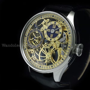 May include: A luxury wristwatch with a silver case and a black leather band. The watch face features a gold-toned skeleton design with blue accents and diamond embellishments. The brand name "BOREL" is visible.